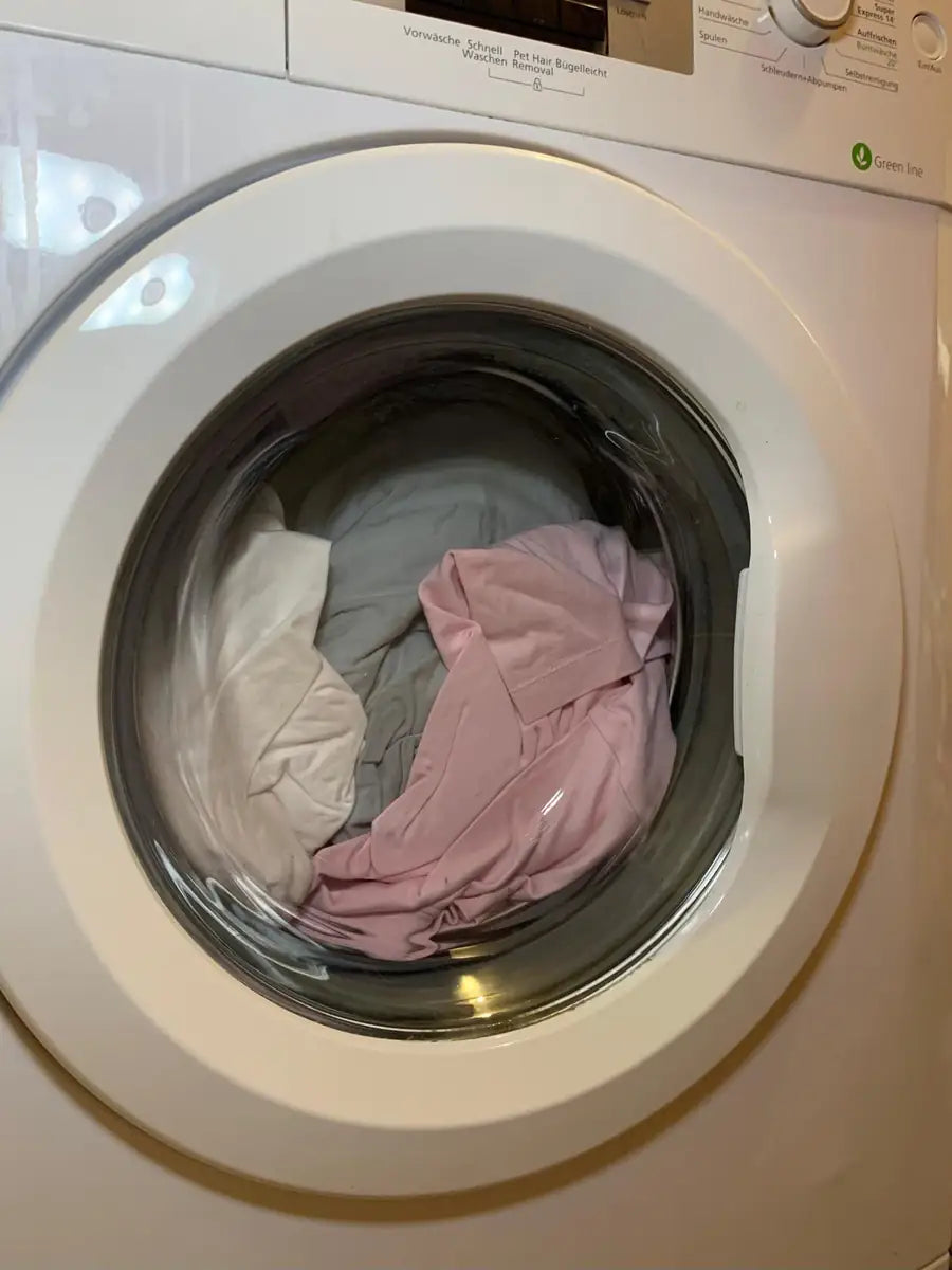 Bunte Wäsche in geschlossener Waschmaschinentrommel